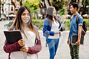 Latin female student, Hispanic girl in Mexico and group of mexican students at Background in Mexico