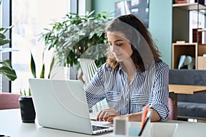 Latin girl college student wearing headphones taking online webinar class.