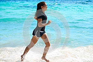 Latin girl running in caribbean shore beach