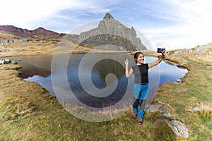 Latin girl taking a selfie in a mountain lake. in the French Pyrenees