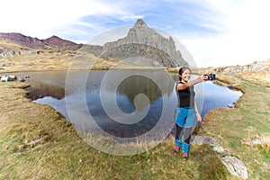 Latin girl taking a selfie in a mountain lake. in the French Pyrenees