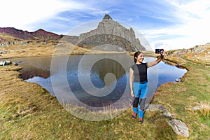 Latin girl taking a selfie in a mountain lake. in the French Pyrenees