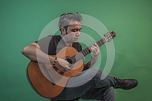 Latin guy with guitar on green background