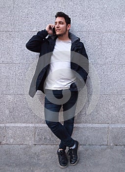 Latin handsome young man talking on the phone and smiling