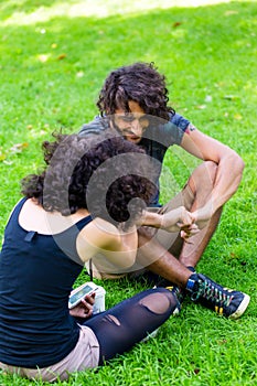 Latin Hipster couple sitting on meadow