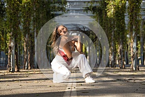 Latin and Hispanic girl, young and beautiful, dancing modern dance in the street outdoors. Dance concept, moonwalk, jumpstyle,