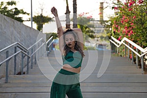 Latin and Hispanic girl, young and beautiful, dancing modern dance in the street outdoors. Dance concept, moonwalk, jumpstyle,