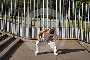 Latin and Hispanic girl, young and beautiful, dancing modern dance in the street outdoors. Dance concept, moonwalk, jumpstyle,