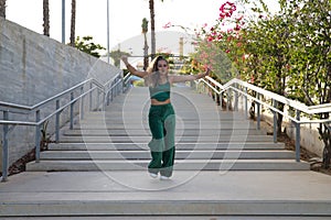 Latin and Hispanic girl, young and beautiful, dancing modern dance in the street outdoors. Dance concept, moonwalk, jumpstyle,