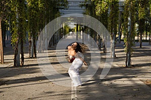 Latin and Hispanic girl, young and beautiful, dancing modern dance in the street outdoors. Dance concept, moonwalk, jumpstyle,