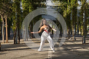 Latin and Hispanic girl, young and beautiful, dancing modern dance in the street outdoors. Dance concept, moonwalk, jumpstyle,