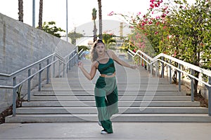 Latin and Hispanic girl, young and beautiful, dancing modern dance in the street outdoors. Dance concept, moonwalk, jumpstyle,