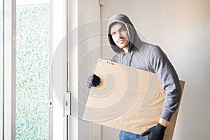 Male robber stealing a piece of art