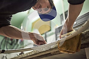 Latin man preparing a bicycle wheel to paint in his workshop