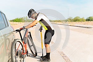 Latin man preparing his bicycle to start training