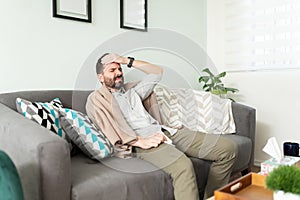 Feverish guy feeling unwell at home photo