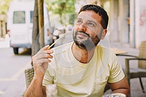 Latin man sitting on a terrace eating sushi and Japanese noodles