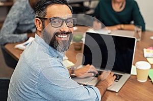 Latin mature businessman working on laptop