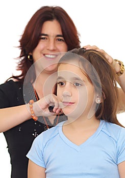 Latin mother combing her small daughter hair