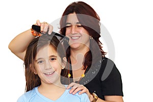Latin mother combing small daughter's hair