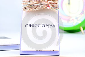 The Latin phrase Carpe Diem, a quote from Horace, means seize the moment. Live in the present written on the desktop calendar