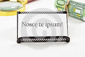 Latin proverb NOSCE TE IPSUM (know yourself) on a white business card