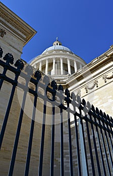 The Pantheon Dome, perspective from below with black iron fence and blue sky. Paris, France.