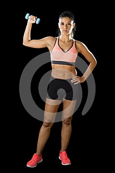 Latin sport woman posing in fierce expression holding dumbbell hand weigh