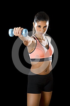 Latin sport woman posing in fierce expression holding dumbbell hand weigh