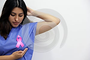 Latin woman disposable blue surgical gown and pink ribbon for campaign against breast cancer