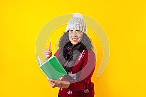 Latin woman holding christmas candles and singing carols on yellow background in Mexico Latin America