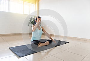 Latin woman in lotus posture practicing a mudra with her hand