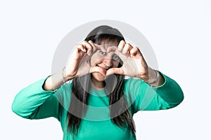 Latin woman making a heart with her hands on isolated white background