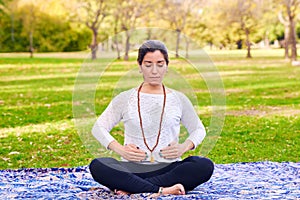 Latin woman performing Reiki poses in a park
