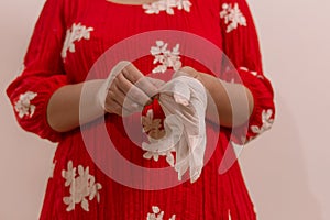 Latin woman with red dress woman taking precautions by covid-19 wear a face mask, gloves and sprayer to prevent infection coronavi photo