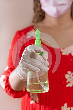 Latin woman with red dress woman taking precautions by covid-19 wear a face mask, gloves and sprayer to prevent infection coronavi