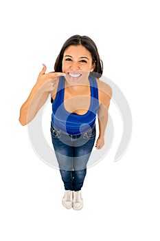 Latin woman smiling happy pointing mouth and whiten teeth with her finger in dental care and hygiene