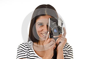 Latin woman taking pictures looking through the viewfinder of an old cool retro vintage photo camera