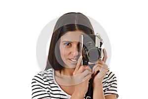 Latin woman taking pictures looking through the viewfinder of an old cool retro vintage photo camera