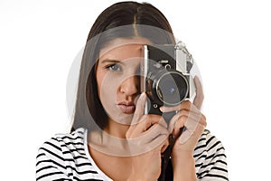 Latin woman taking pictures looking through the viewfinder of an old cool retro vintage photo camera