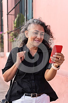 Latin Woman Using Mobile Phone In The Street