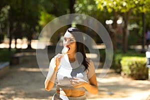 Latin woman, young and beautiful brunette eats a refreshing ice cream to combat the high temperatures in the city. Heat wave and