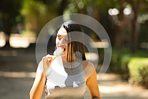 Latin woman, young and beautiful brunette eats a refreshing ice cream to combat the high temperatures in the city. Heat wave and