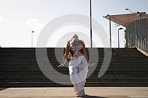 Latin woman, young and beautiful dancing modern dance in the street and makes different expressions and postures. Concept dance,