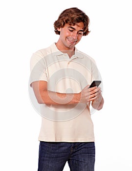 Latin young man in jeans reading on cellphone