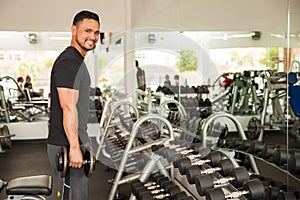 Latin young man lifting weights in a gym