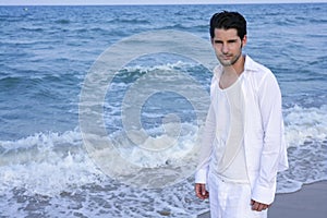 Latin young man white shirt walking blue beach