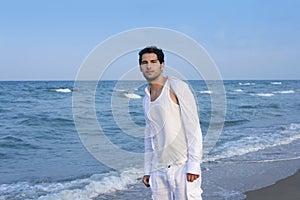 Latin young man white shirt walking blue beach