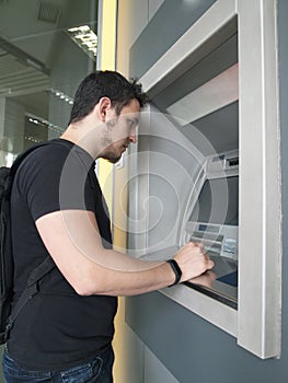 Latin young man withdrawing money from a cashpoint machine