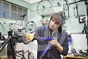 Latin young man working on a custom bike frame painting design in his workshop